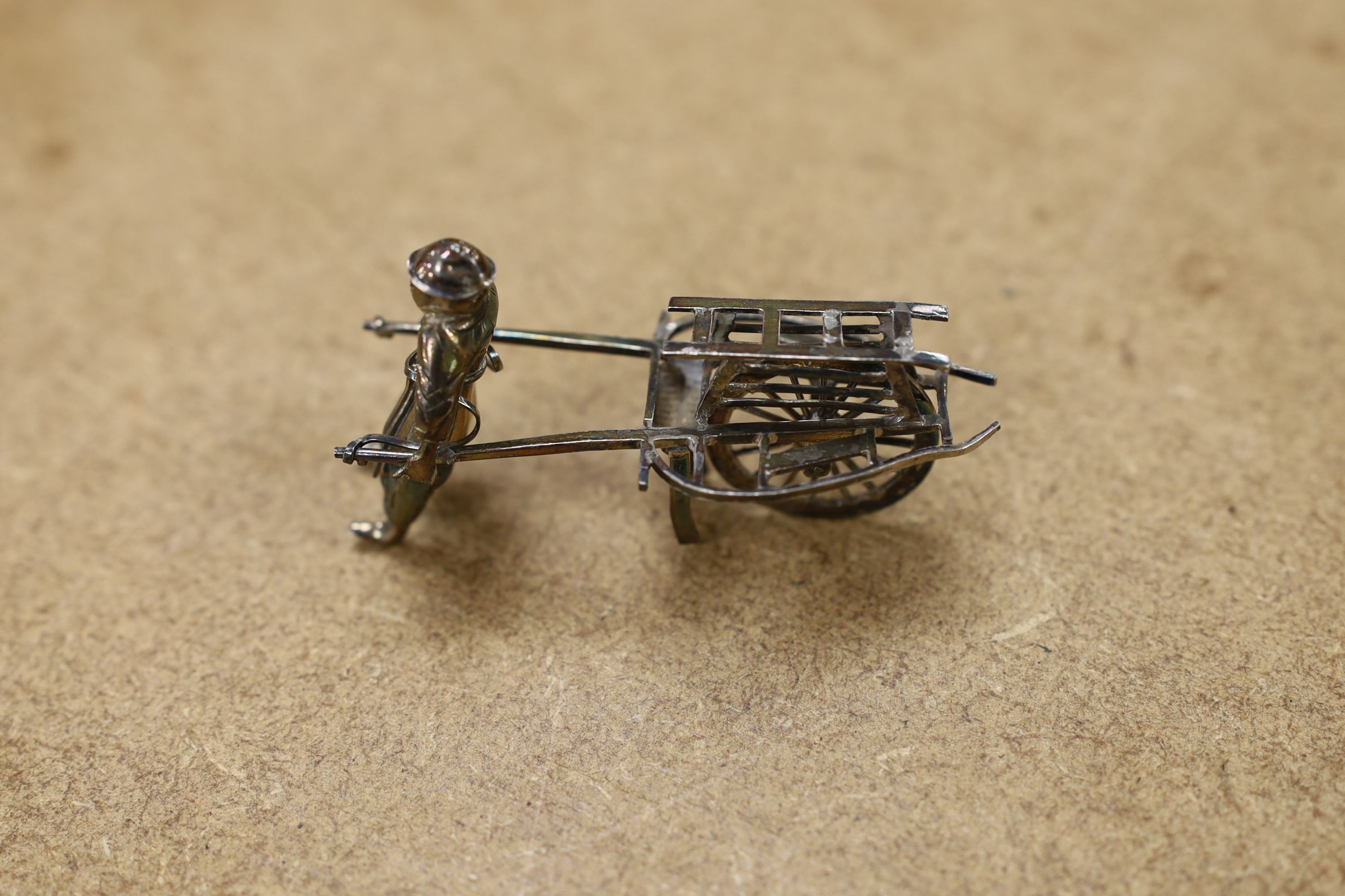 Six assorted miniature white metal items including a Chinese tea kettle on stand (lacking lid), height 93mm, maker CS, a similar rickshaw with driver, maker CH, a Chinese condiment and three other items.